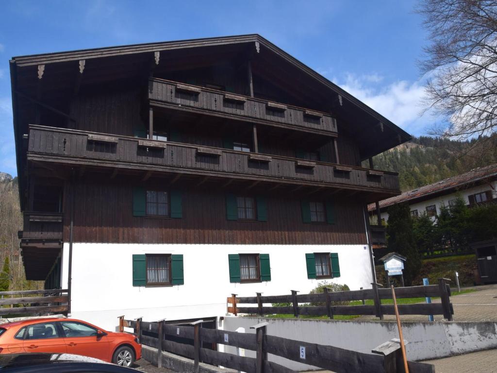 an orange car parked in front of a large building at Inviting Apartment in Bayrischzell with 2 Sauna, Garden and Terrace in Bayrischzell