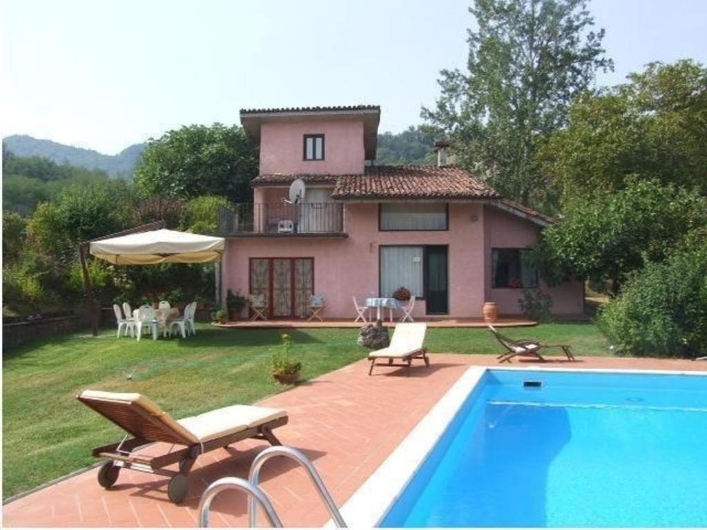 a house with a swimming pool in front of a house at Ferienhaus in Camporgiano mit Grill und Terrasse in Poggio