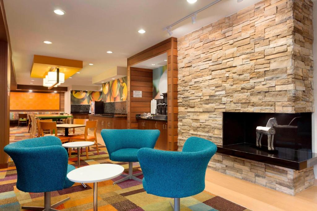 a lobby with blue chairs and a fireplace at Fairfield Inn & Suites Waco South in Waco