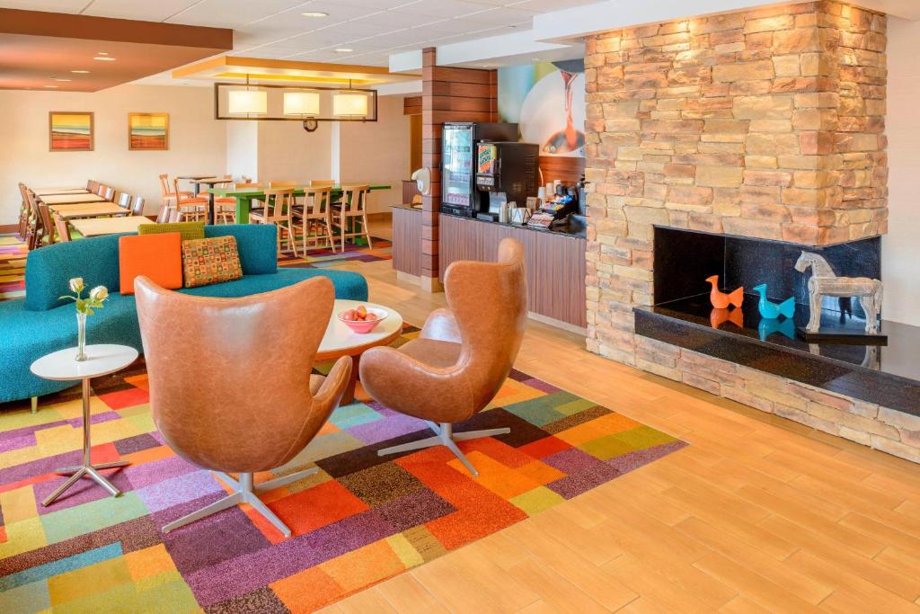 a lobby with a couch and chairs and a fireplace at Fairfield Inn Joplin in Joplin