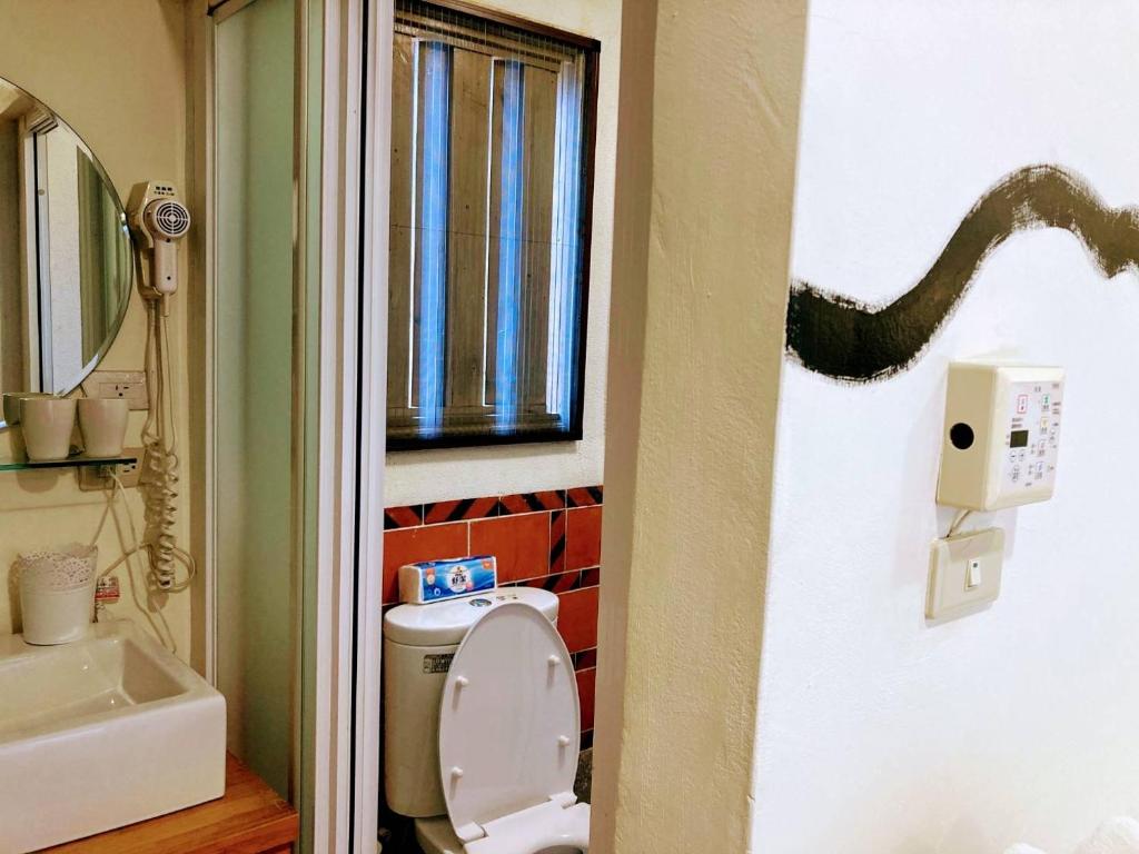 a bathroom with a toilet and a snake on the wall at Shenten Homestay in Jincheng