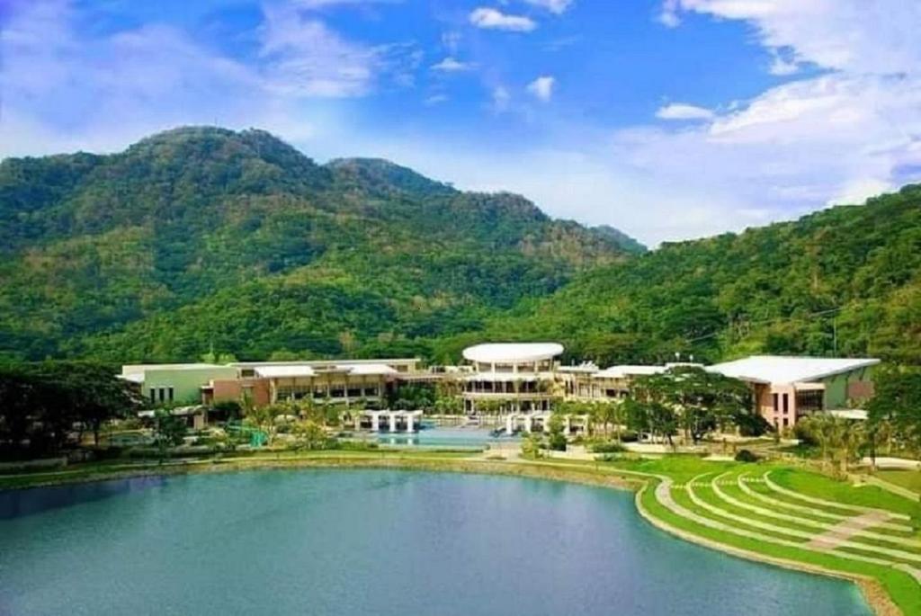 a resort with a pool in front of a mountain at Pico De Loro Hamilo Coast beach and Country Club - Myna B One Bedroom in Cutad