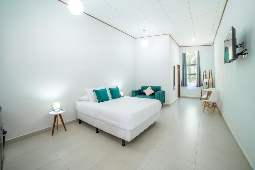 a bedroom with a white bed and blue pillows at Natüra Hotel Monteverde in Monteverde Costa Rica