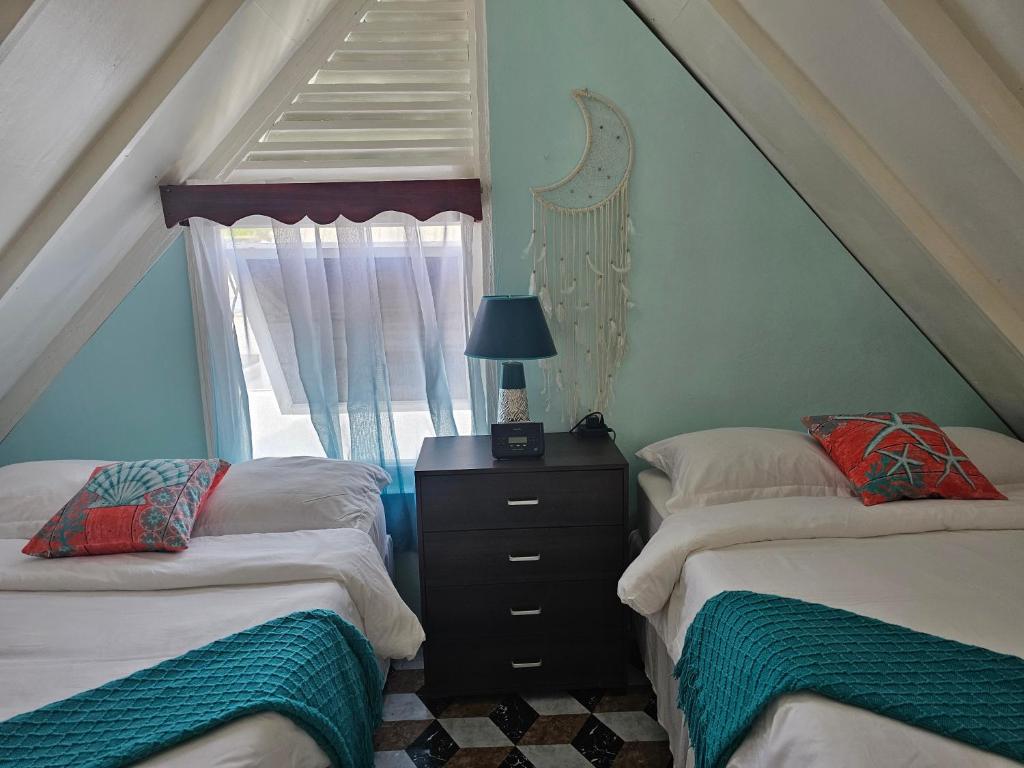 a attic room with two beds and a staircase at Memories by the Shore in Negril