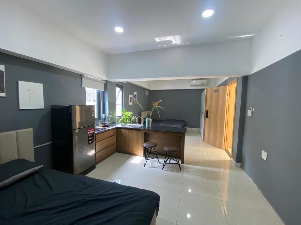 Il comprend une chambre avec un lit et une cuisine équipée d'un réfrigérateur. dans l'établissement Ngọ house, à Hô-Chi-Minh-Ville