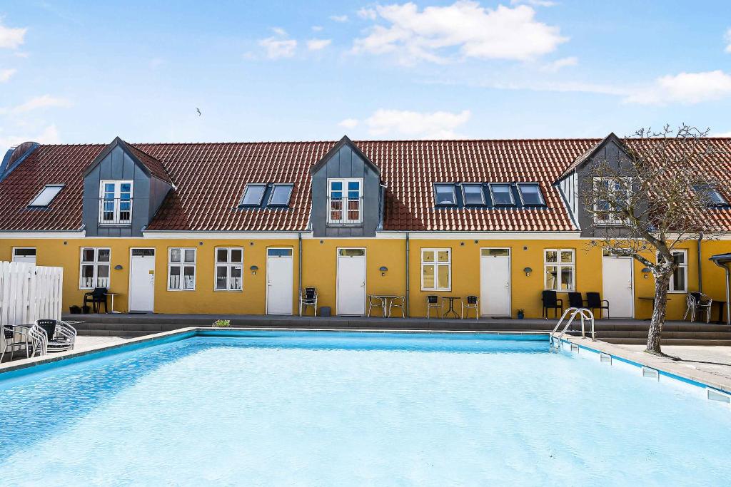 a large swimming pool in front of a yellow building at Brddegade 14, 3760 Gudhjem in Gudhjem