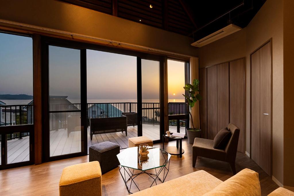 uma sala de estar com vista para uma varanda em Goshikihama Villa 
