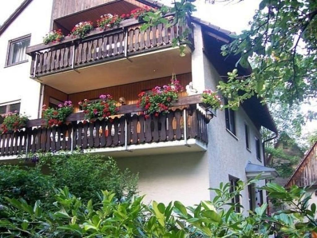 a building with a balcony with flowers on it at Erdgeschoss-Wohnung mit privater Terrasse für sechs Personen in Gößweinstein