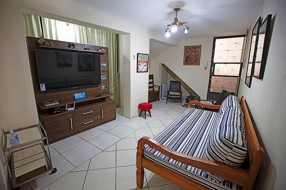 ein Wohnzimmer mit einem Bett und einem Flachbild-TV in der Unterkunft Recanto São Francisco, Casa 2 quartos 100m Igreja São Francisco Pet friend in São João del Rei