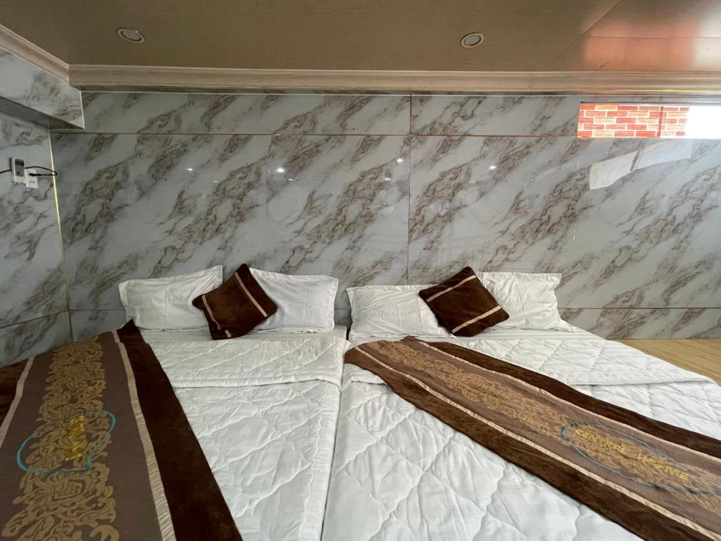 Centralhome 2 في Plei Brêng: سريرين في غرفة ذات جدار من الرخام