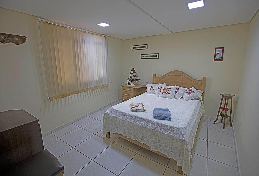 a bedroom with a bed with two pillows on it at Recanto São Francisco, Casa 2 quartos 100m Igreja São Francisco Pet friend in São João del Rei