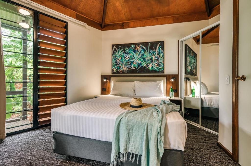 a bedroom with a bed with a hat on it at Palms City Resort in Darwin