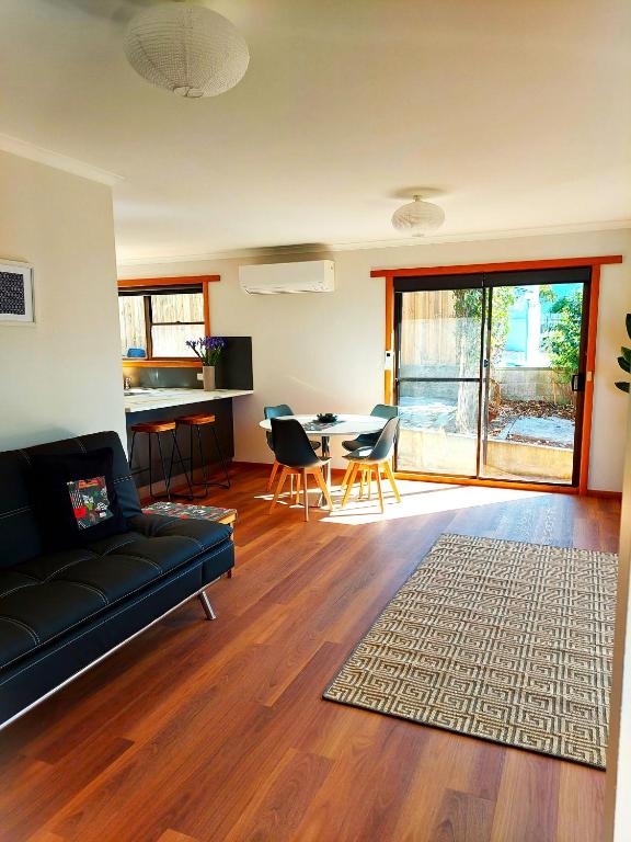 a living room with a couch and a table at Percy's Cottage in Devonport
