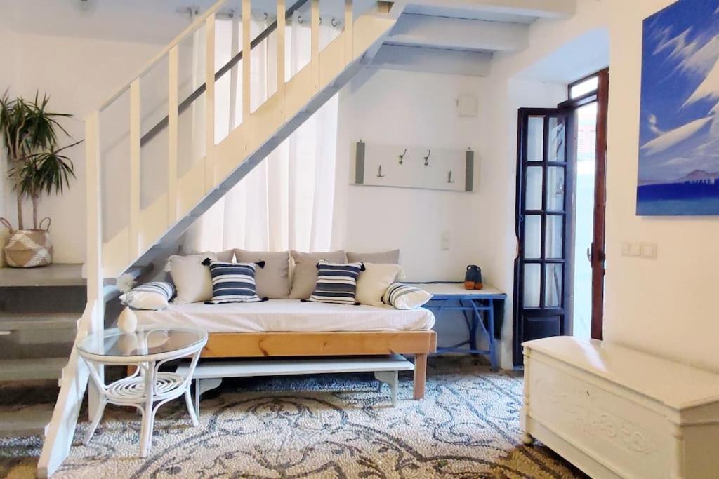 a living room with a couch and a staircase at Town House with Rooftop Jacuzzi in Rhodes Town