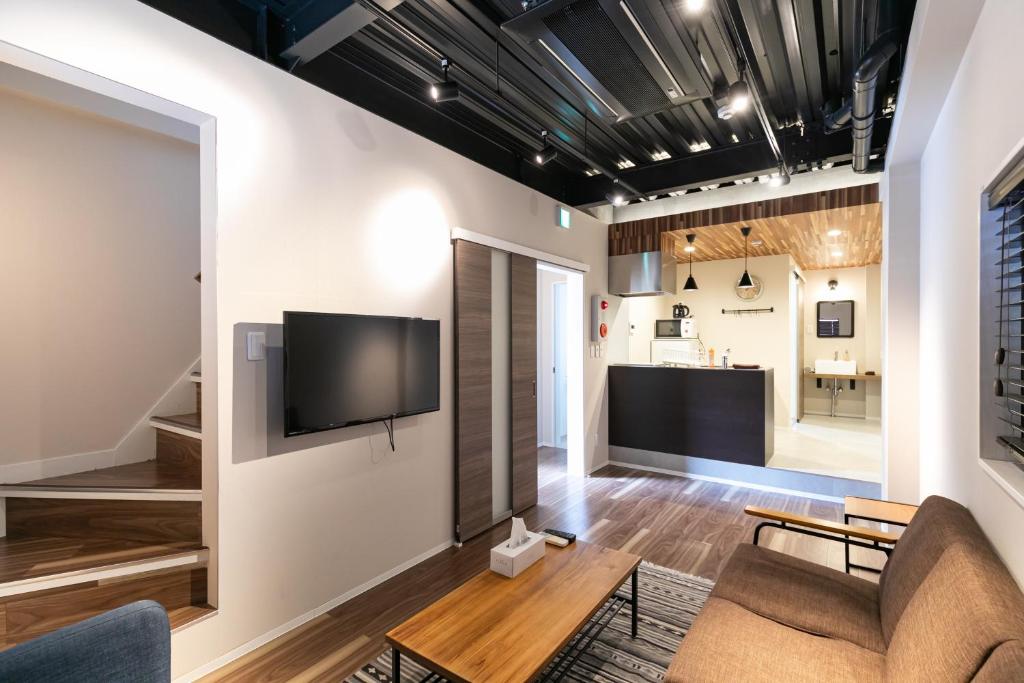 a living room with a tv and a couch at Shinosaka private house for 16ppl in Osaka