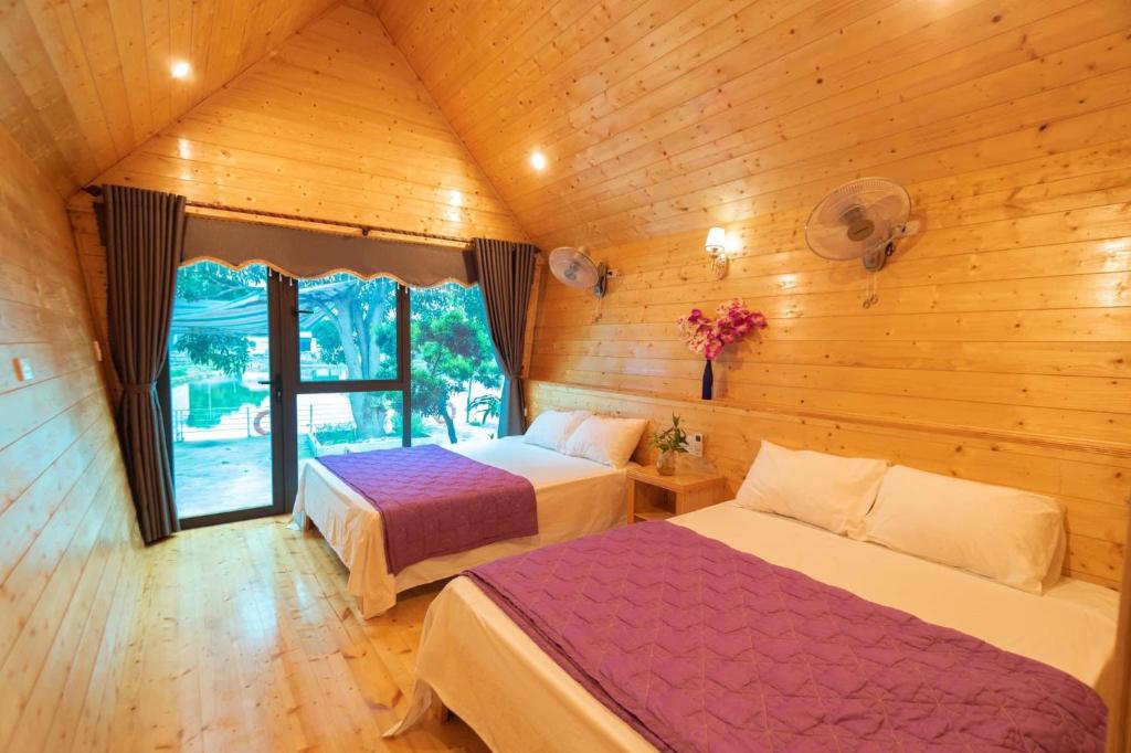 um quarto com 2 camas num chalé de madeira em Cô Tô Lương Chi em Quang Ninh