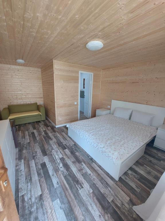 a bedroom with a white bed and a wooden ceiling at Cabana Oprișor in Ocna Sibiului