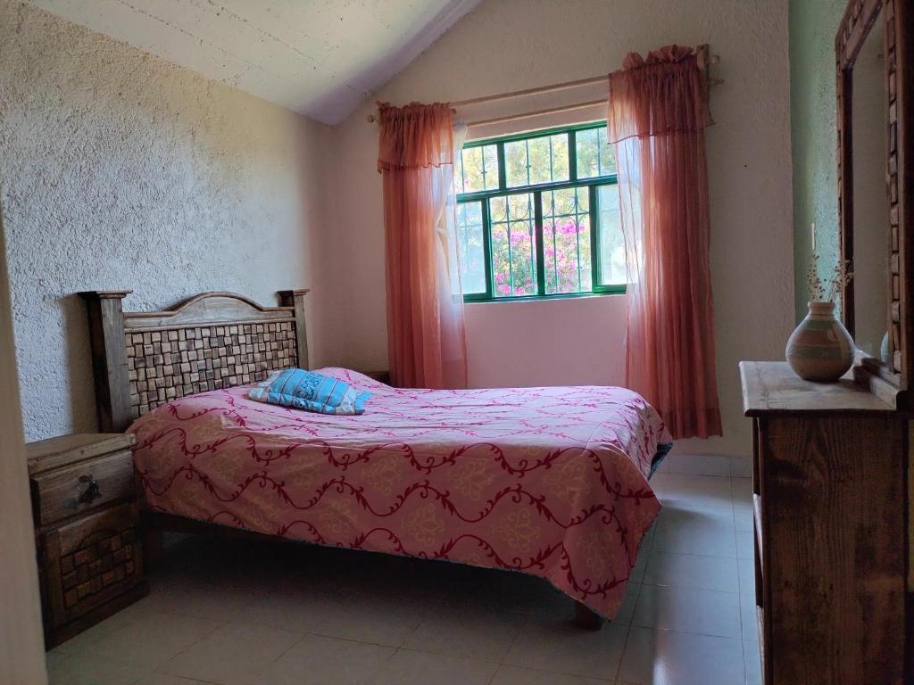 - une chambre avec un lit et une fenêtre avec des rideaux rouges dans l'établissement Casa de campo, Huasca Hidalgo, à Huasca de Ocampo
