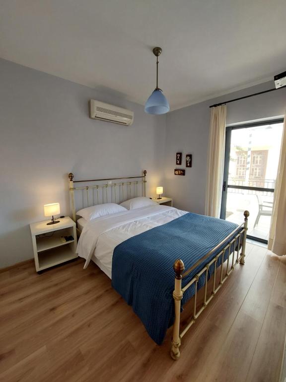 a bedroom with a large bed with a blue blanket at Notos Guesthouse in Monemvasia