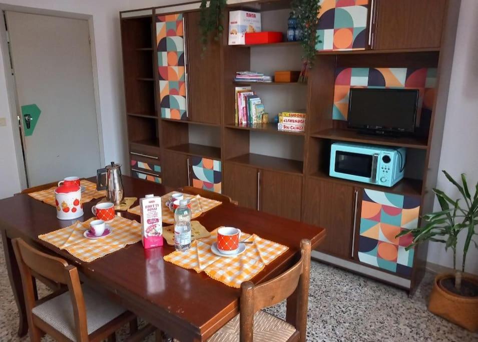 une table à manger avec des chaises et une télévision dans l'établissement Ampio appartamento per 4/6 pers, à Cesenatico