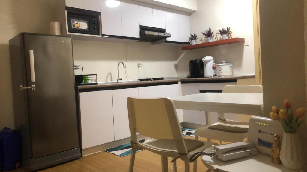 a small kitchen with a table and a refrigerator at Cozy Home 1 bedroom in Manila