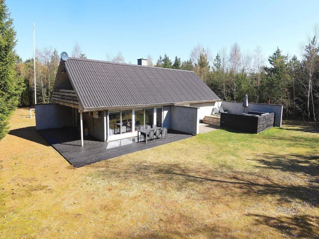 a house with a deck in the middle of a yard at 6 person holiday home in H jslev in Højslev