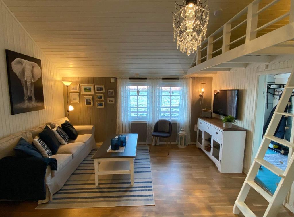 a living room with a couch and a table at Lofotbua in Offersøya