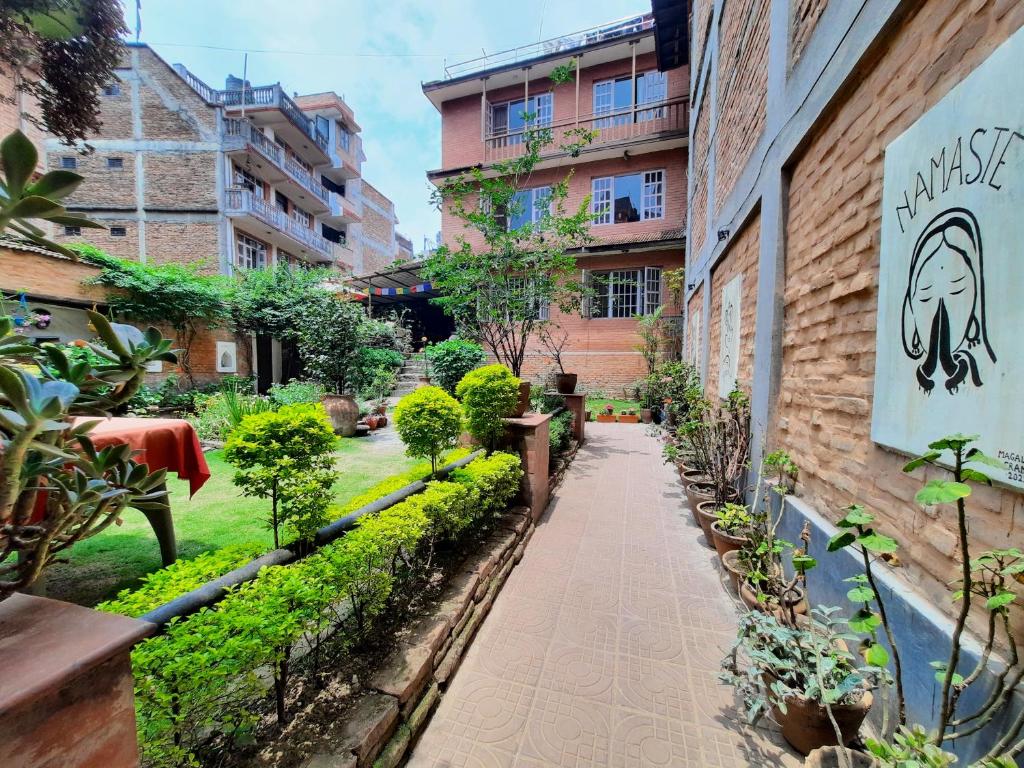 a garden outside a building with trees and plants at Pradhan House - Home Stay with Garden in Bhaktapur