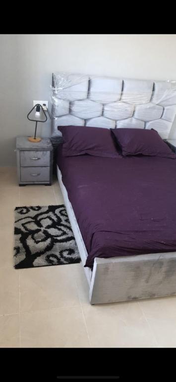 um quarto com uma cama grande com lençóis roxos e um tapete em DAR SALAM 