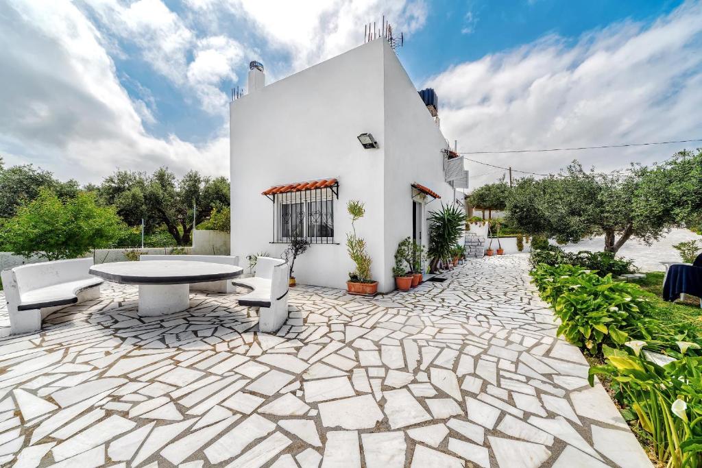 a patio with a table and chairs and a building at Calma Home in Prasás