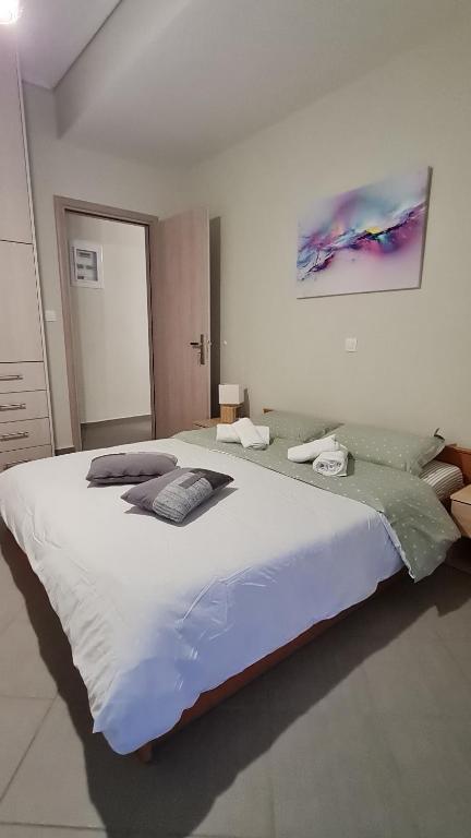 - duże białe łóżko w białym pokoju w obiekcie Eretria Apartments EK9 w Erétrii
