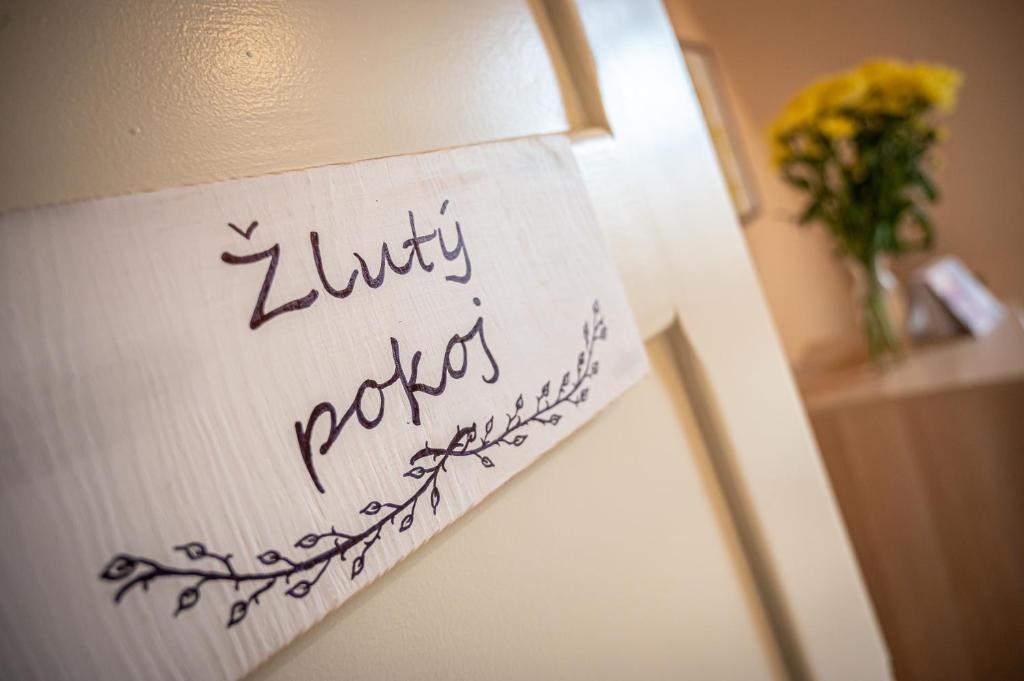 a sign on the side of a lamp with a vase of flowers at Vila Lumír in Poděbrady