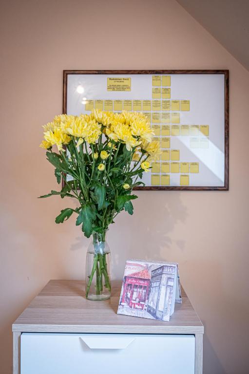 a vase of yellow flowers on top of a table at Vila Lumír in Poděbrady