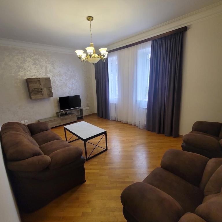 a living room with two couches and a table at Family home in Yerevan