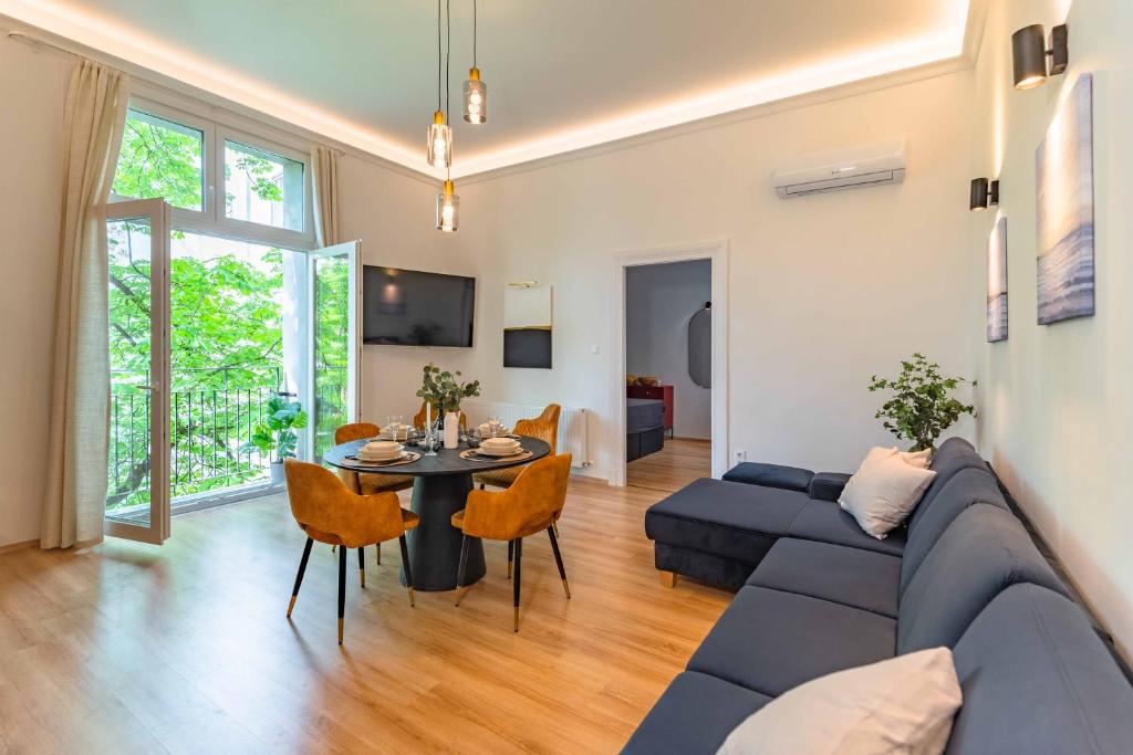 uma sala de estar com um sofá azul e uma mesa em Modern Apartment French Balkony em Budapeste