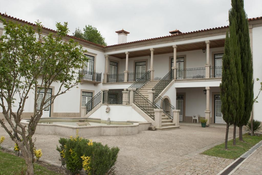 an exterior view of a large white building with stairs at Casa do Fontão in Amarante
