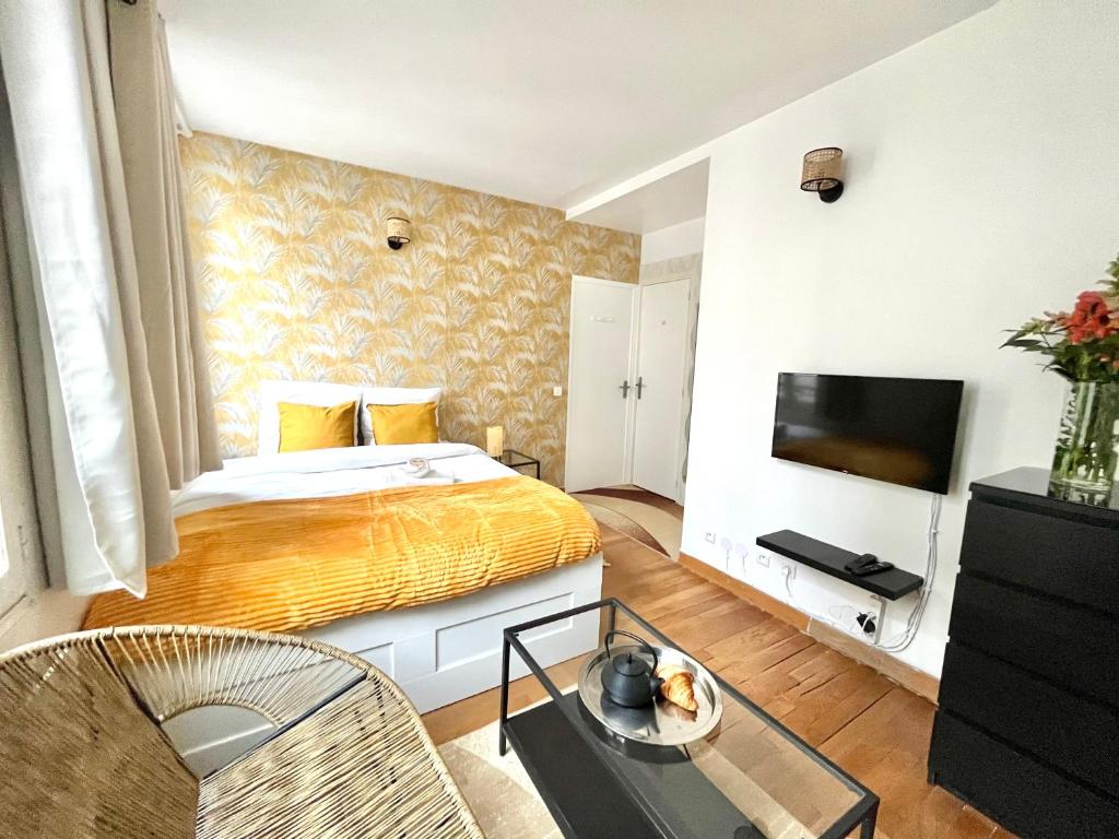 une chambre d'hôtel avec un lit et une télévision dans l'établissement Cosy appartment in the marais district, à Paris