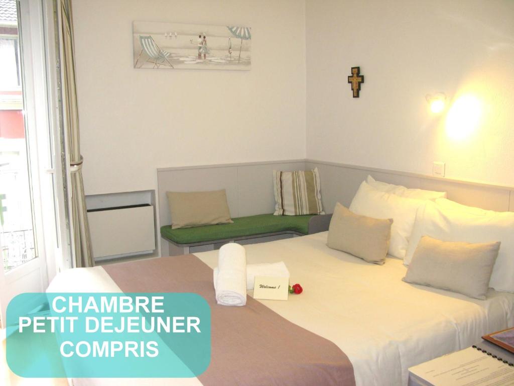 um quarto com uma cama grande e um banco verde em Au Berceau de Bernadette em Lourdes