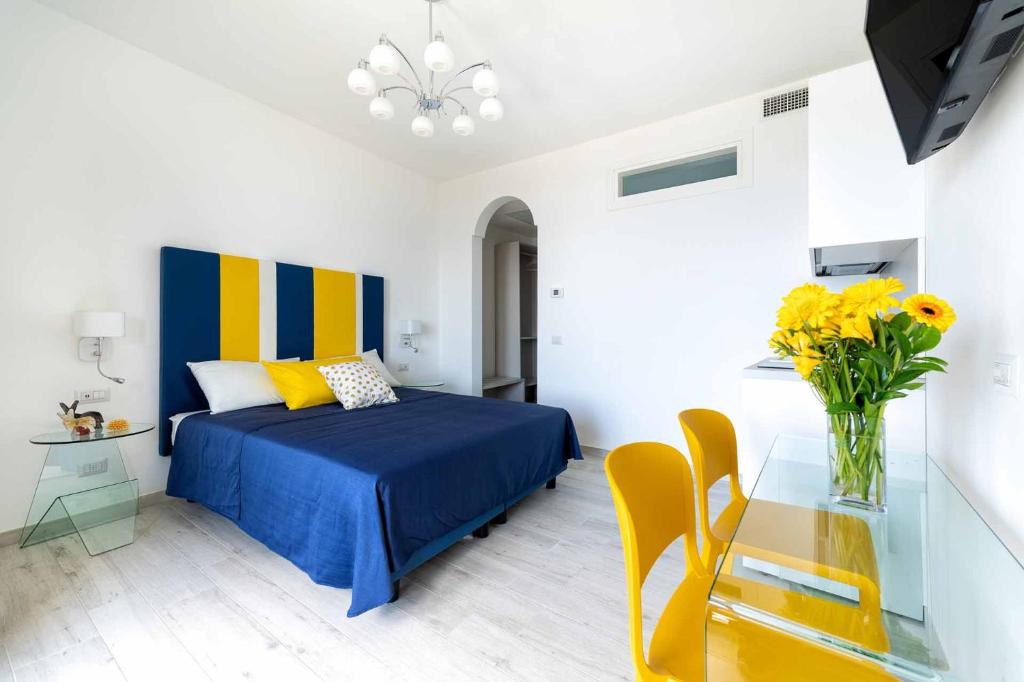 Un dormitorio con una cama y una mesa con un jarrón de flores en Tenuta dell'Al.Ma. en Amalfi
