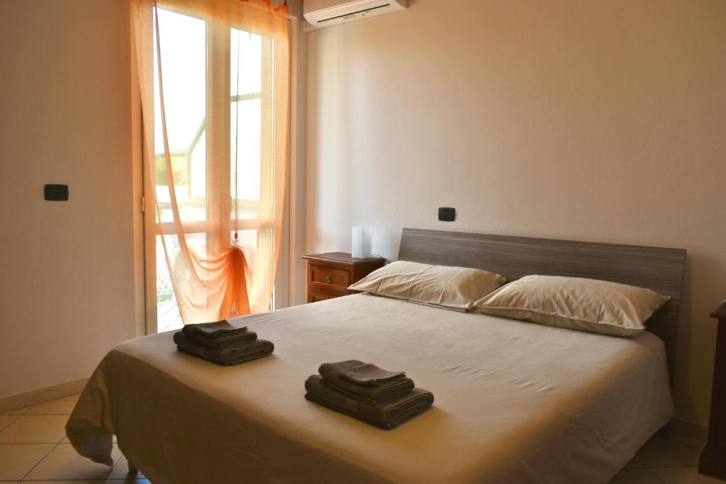 1 dormitorio con 1 cama con 2 toallas en Orange Apartment, en Marina di Massa