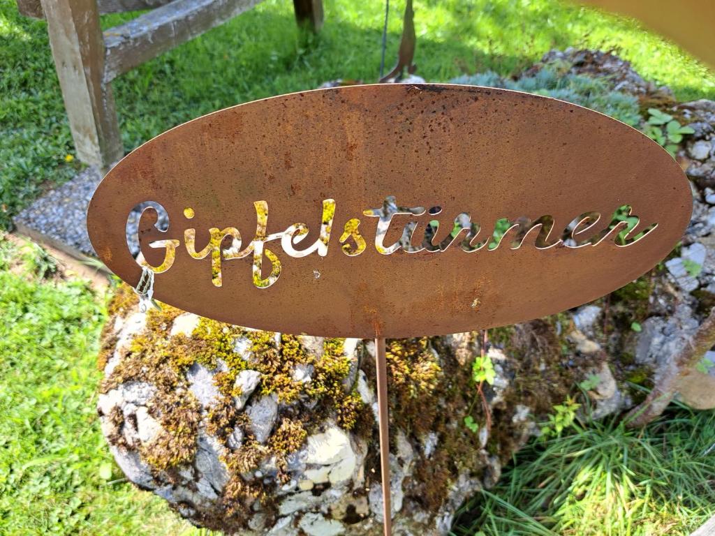 un signo que dice curiculture en la cima de una roca en Ferienwohnung Gipfelstürmer en Gunzesried