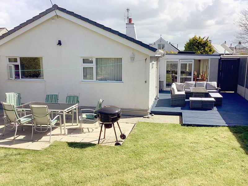 a backyard with a bbq and a grill in the grass at Gilfach-3 Bed-Dog Friendly-Detached Bungalow in Trearddur