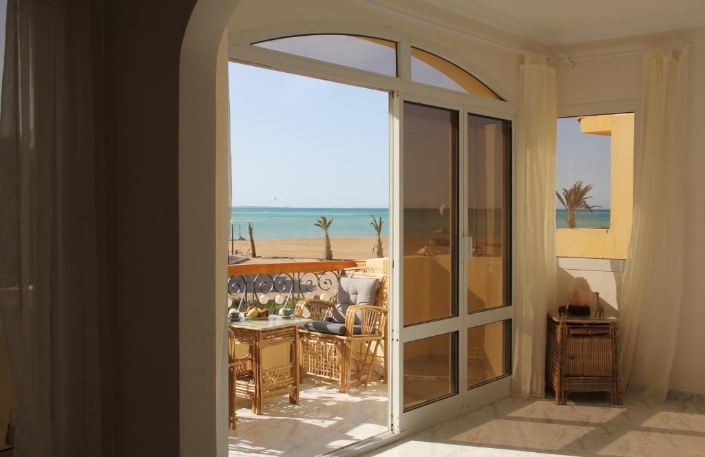 una porta aperta su un balcone con vista sulla spiaggia di Villa Anna & Snake a Hurghada