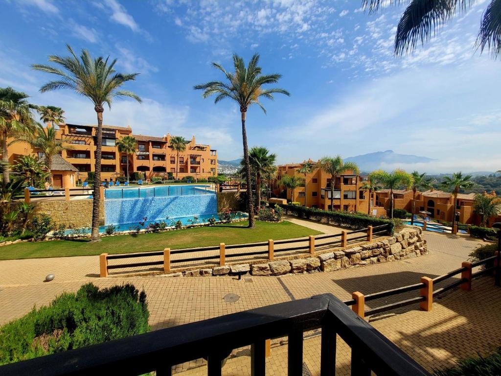 a view of a resort with a swimming pool and palm trees at Secret View Benahavis in Benahavís