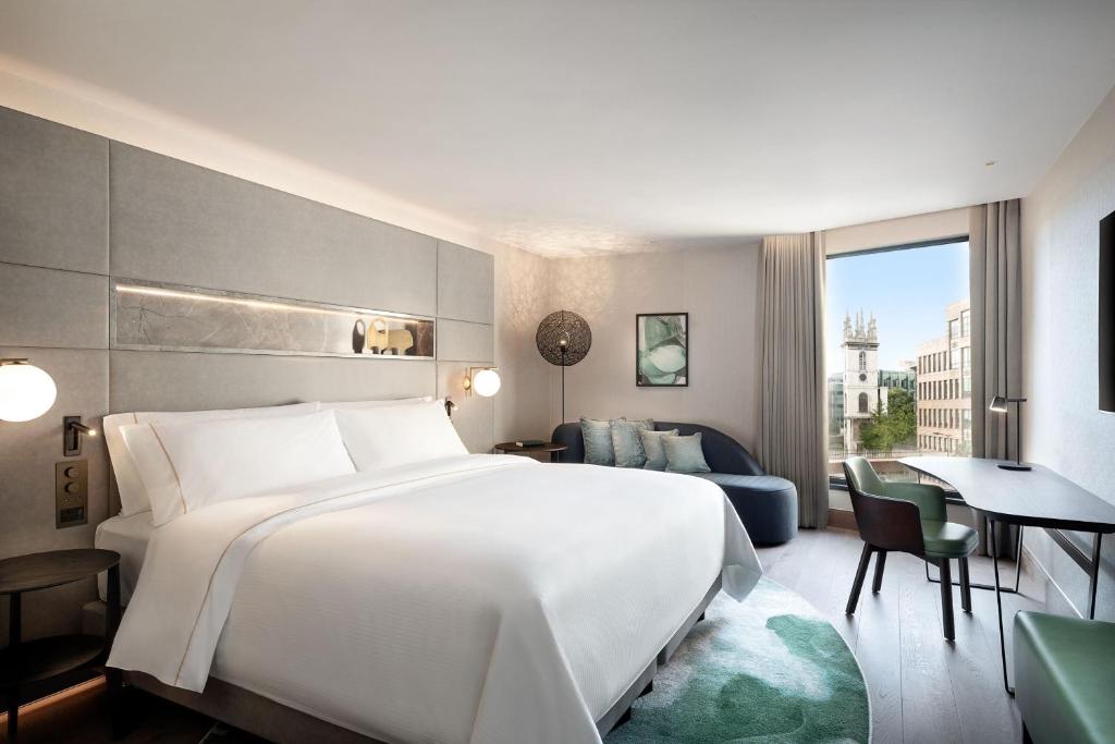 a hotel room with a large bed and a desk at The Westin London City in London