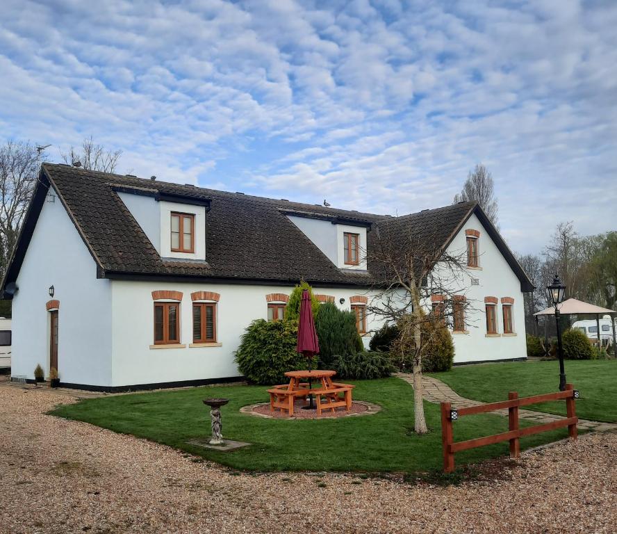 a white house with a picnic table in front of it at Langdale Lodge in Lincoln