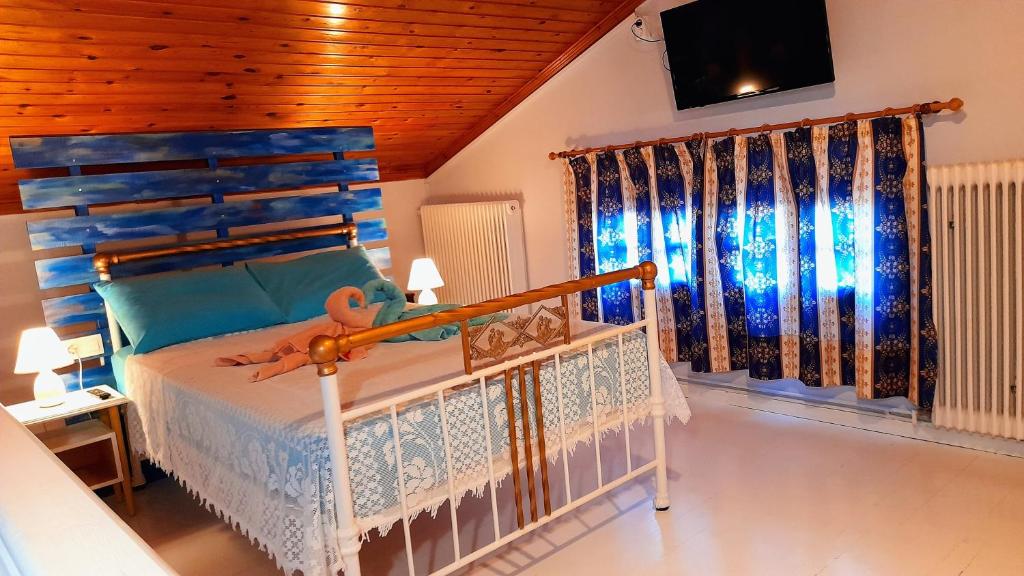 a bedroom with a bed with a blue headboard at Katia's ATTIC in Acharavi