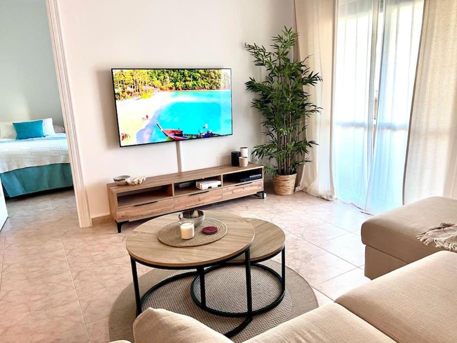 a living room with a tv and a coffee table at Casa Oikos - La Cala de Mijas in La Cala de Mijas