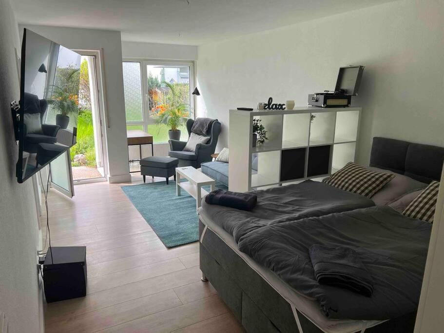 ein Schlafzimmer mit einem Bett und ein Wohnzimmer in der Unterkunft Wunderschöne 1-Zimmer Wohnung in Wiesbaden