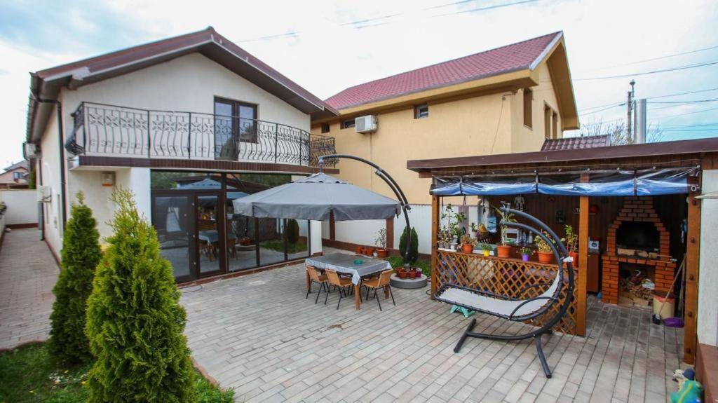 een huis met een patio met een tafel en een parasol bij Casa Ryn Navodari in Năvodari